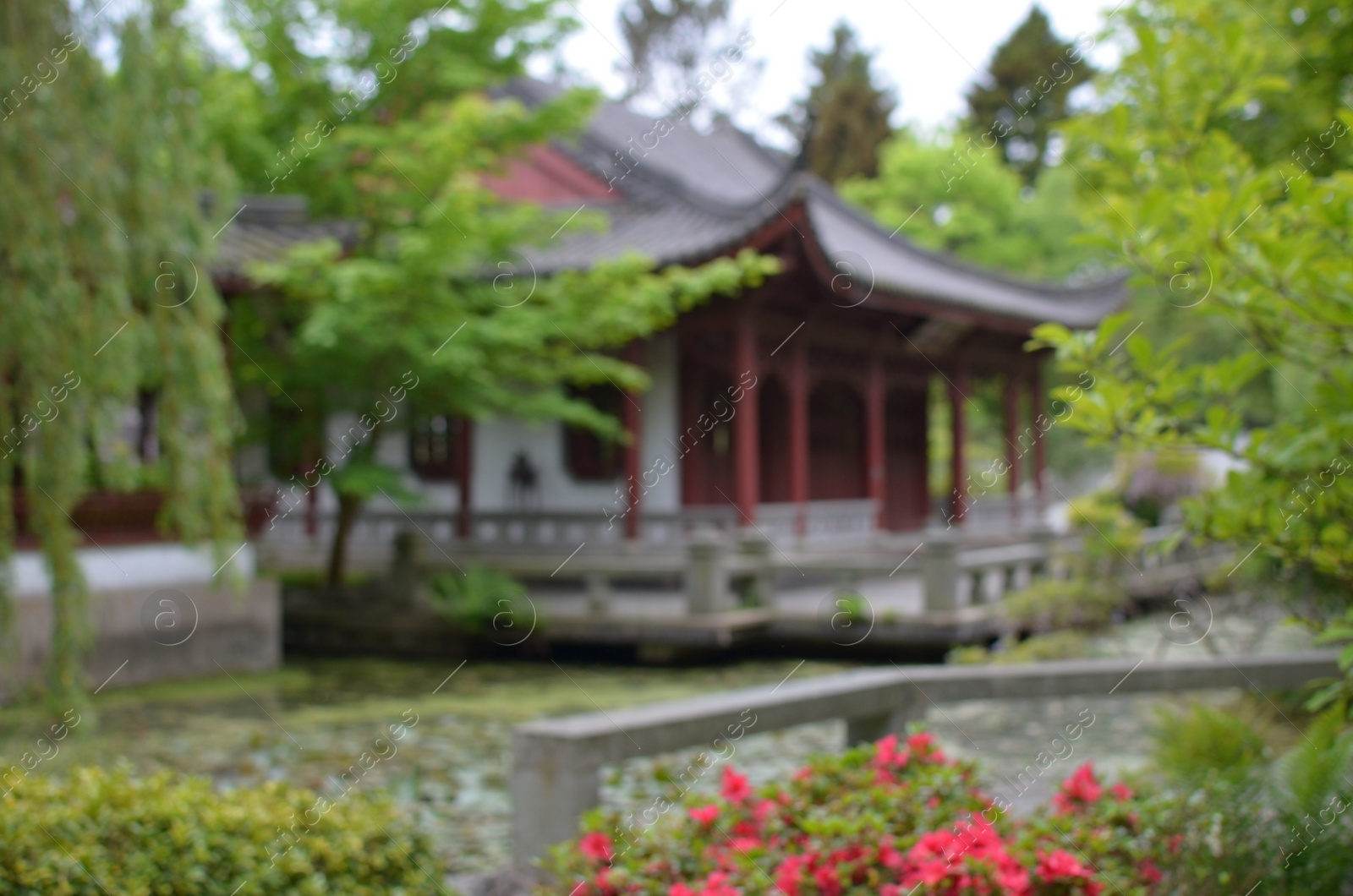 Photo of Beautiful view of oriental building near pond in park