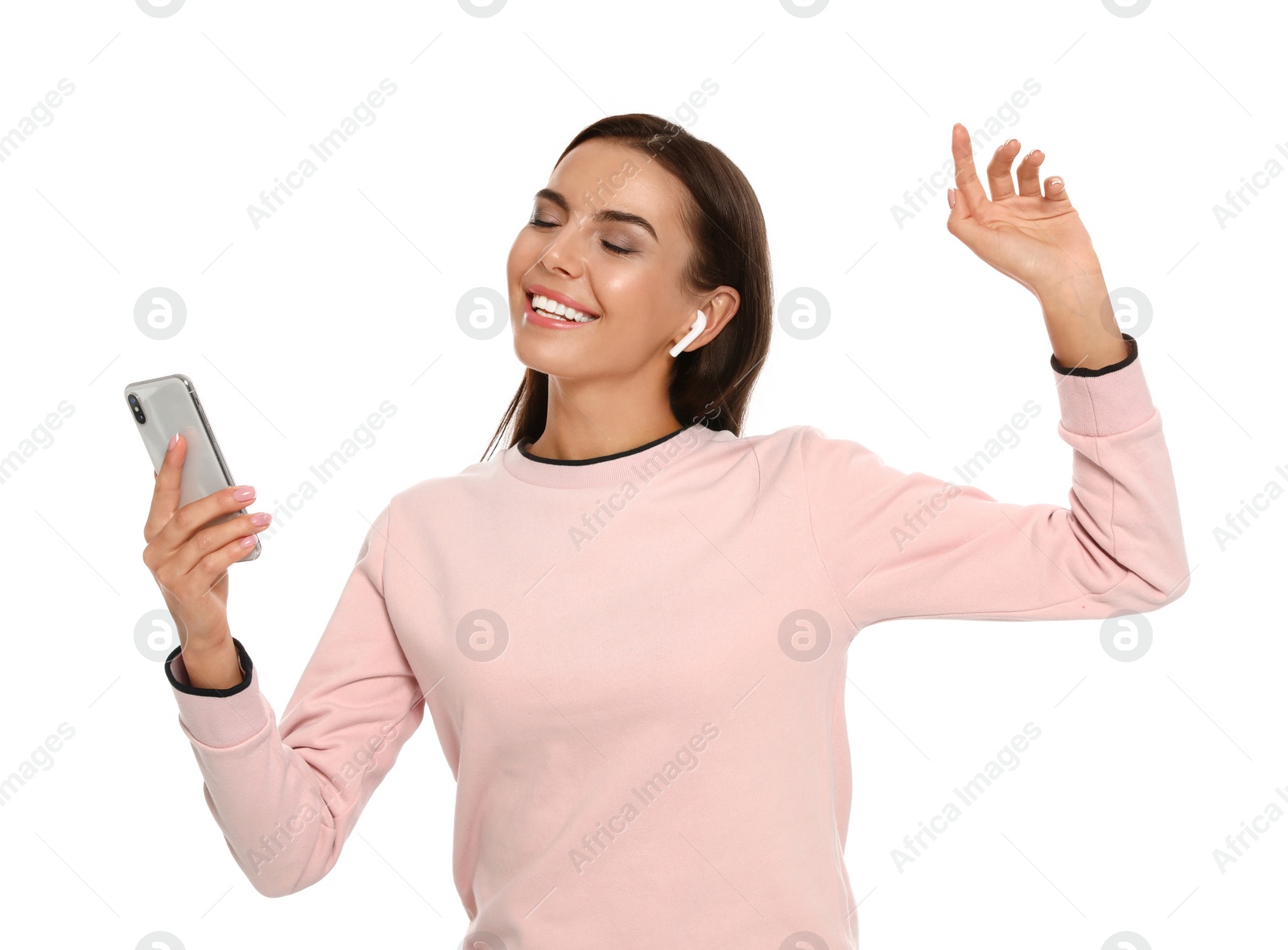 Photo of Happy young woman with smartphone listening to music through wireless earphones on white background