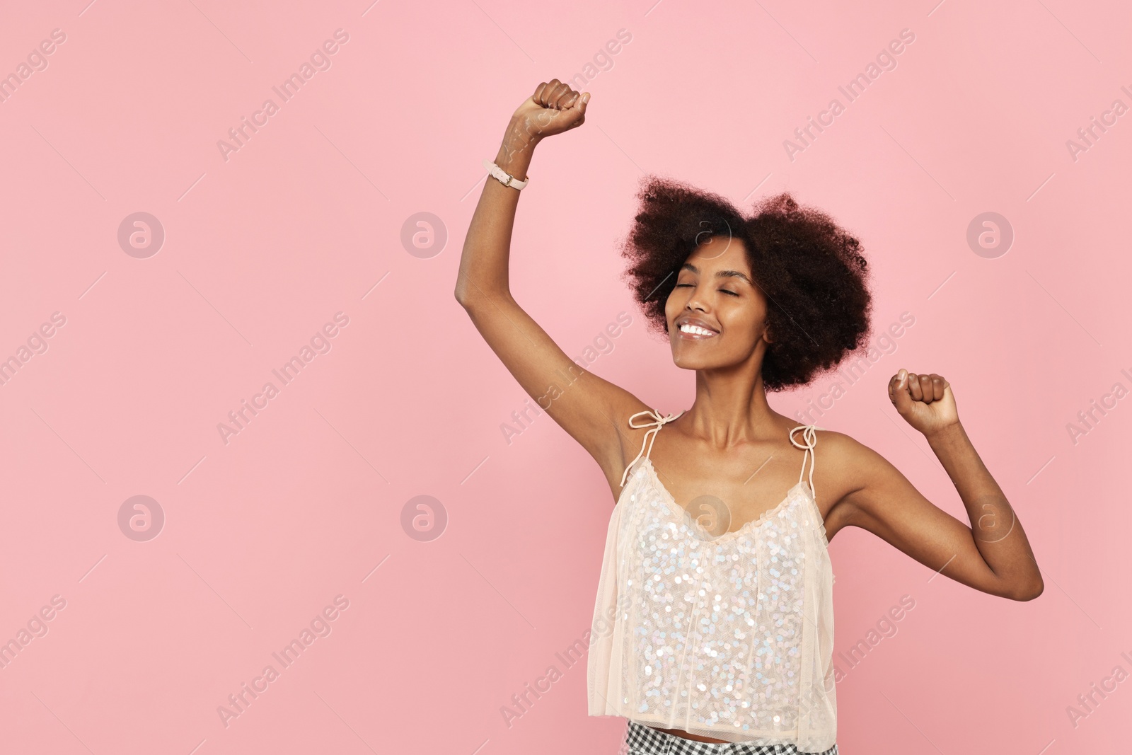 Photo of Portrait of smiling African American woman on pink background. Space for text