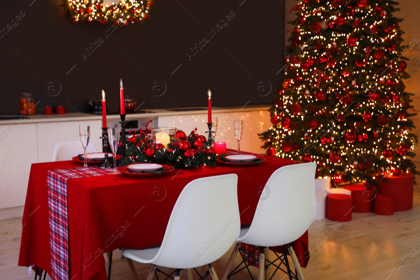 Photo of Stylish kitchen interior with festive table and decorated Christmas tree