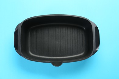 Photo of Black pot on light blue background, top view