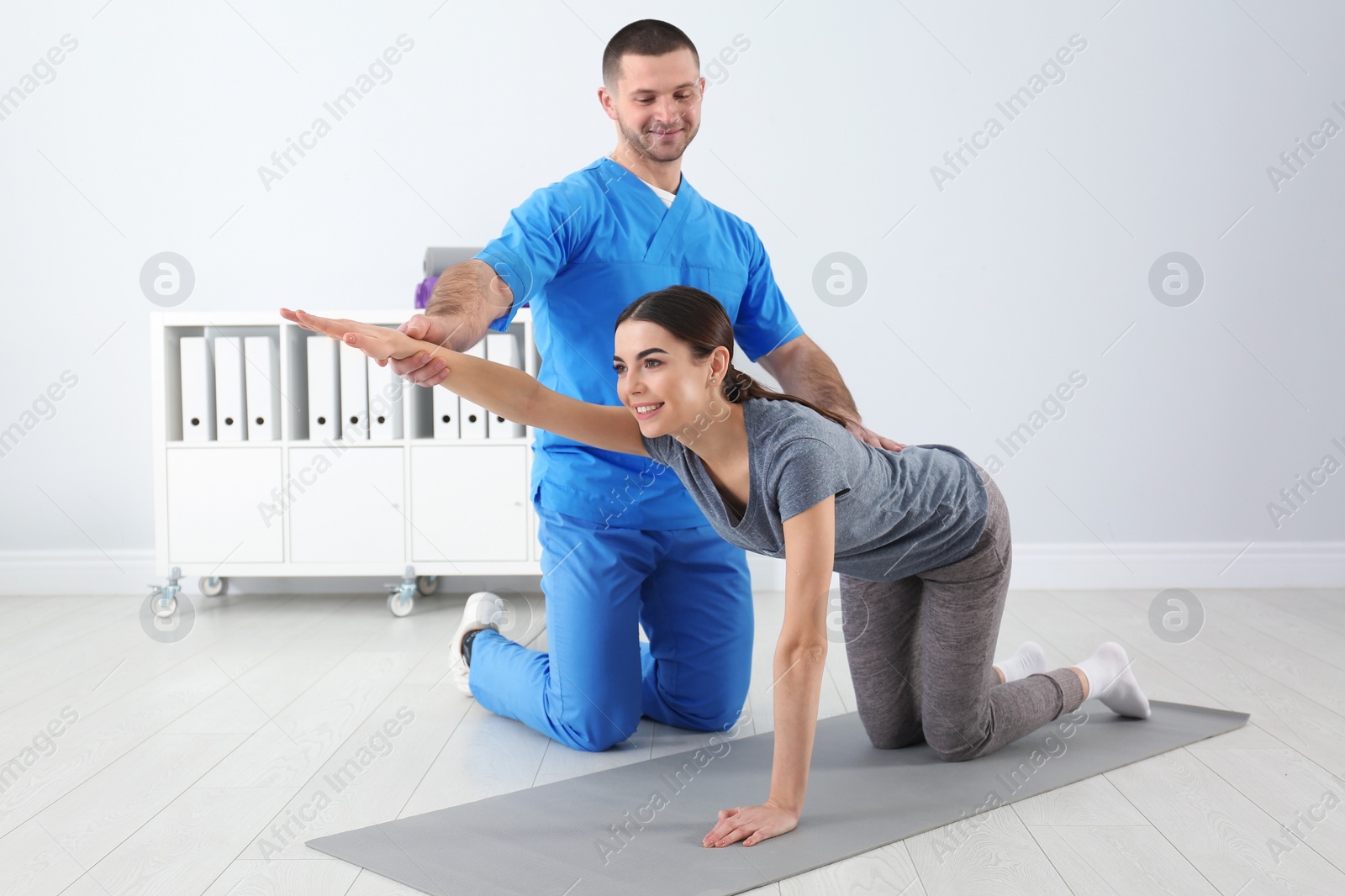 Photo of Doctor working with patient in hospital. Rehabilitation exercises