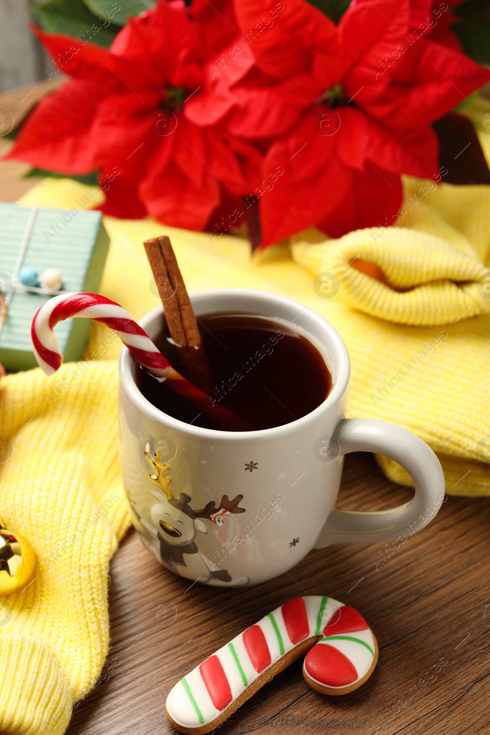 Photo of Composition with cup of hot drink and yellow sweater on wooden table