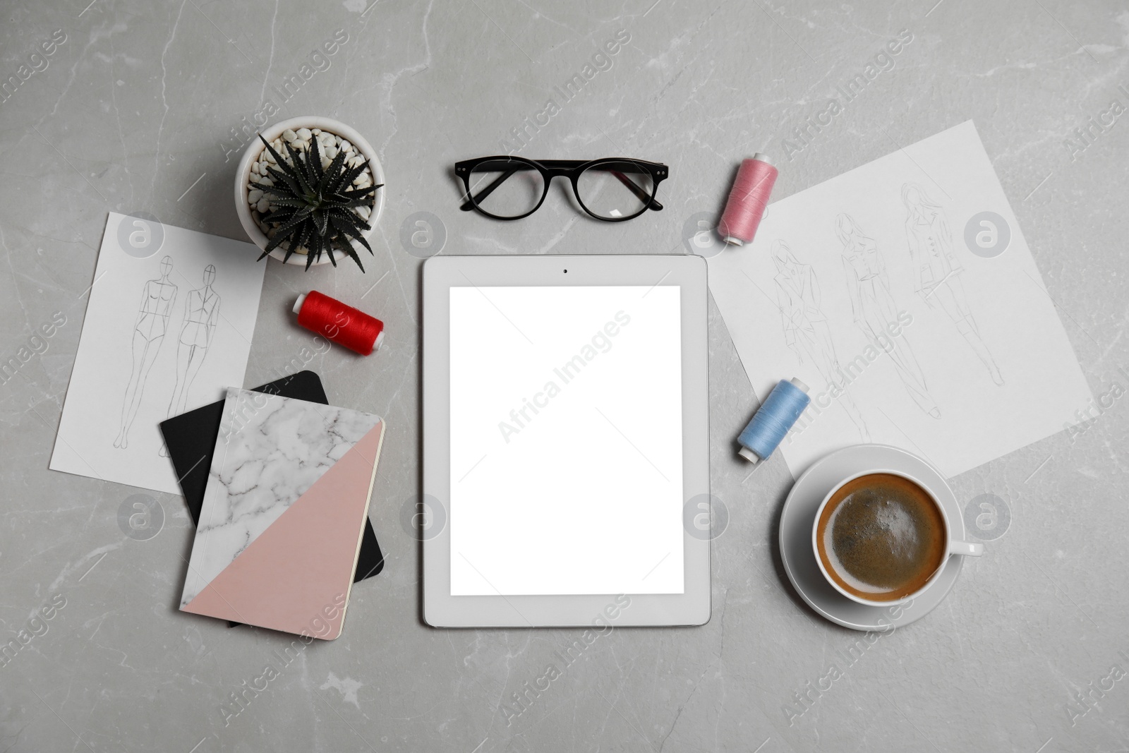 Photo of Flat lay composition with modern tablet and accessories on grey marble table. Designer's workplace