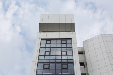 Photo of Modern office building against sky with clouds