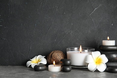 Photo of Spa composition with stones and candles on table, space for text