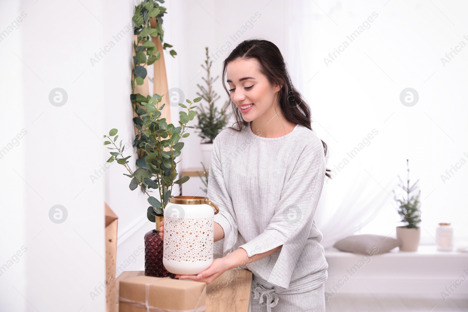 Photo of Woman decorating home interior with eucalyptus branches