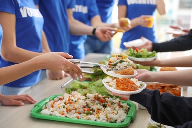 Volunteers serving food to poor people, closeup