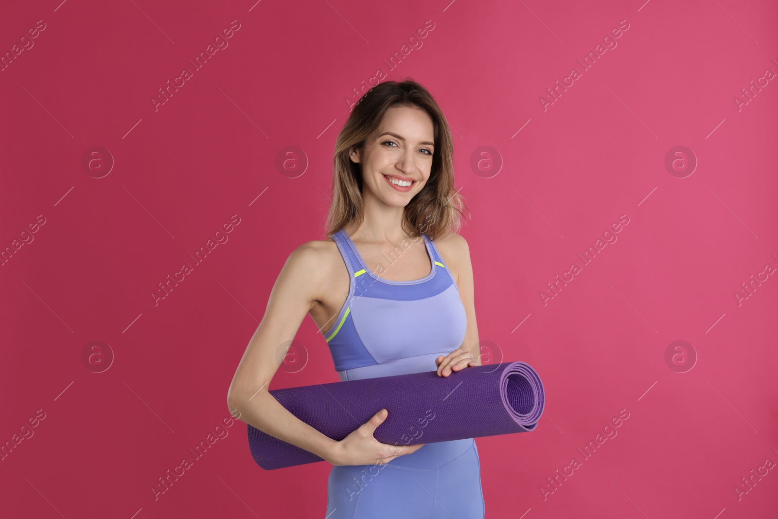 Photo of Beautiful woman with yoga mat on pink background