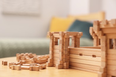 Photo of Wooden fortress and building blocks on table indoors, space for text. Children's toy
