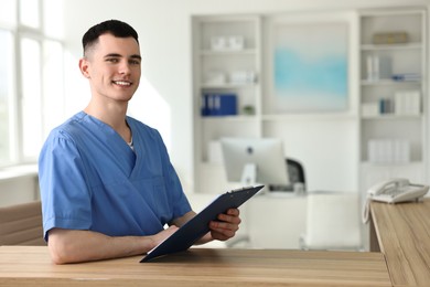 Photo of Smiling medical assistant with clipboard at hospital reception. Space for text
