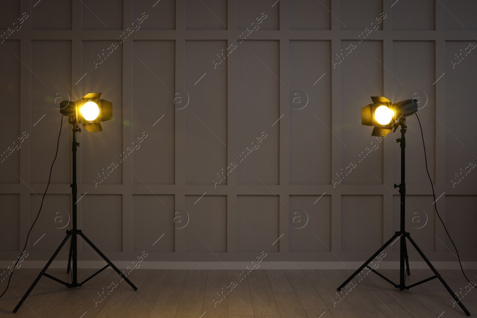 Photo of Bright yellow spotlights near wall indoors, space for text