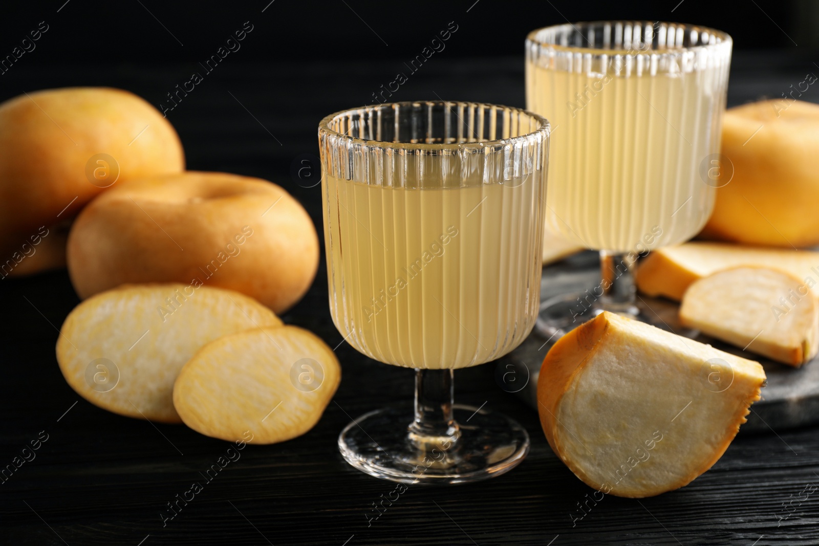 Photo of Freshly made turnip juice on black wooden table