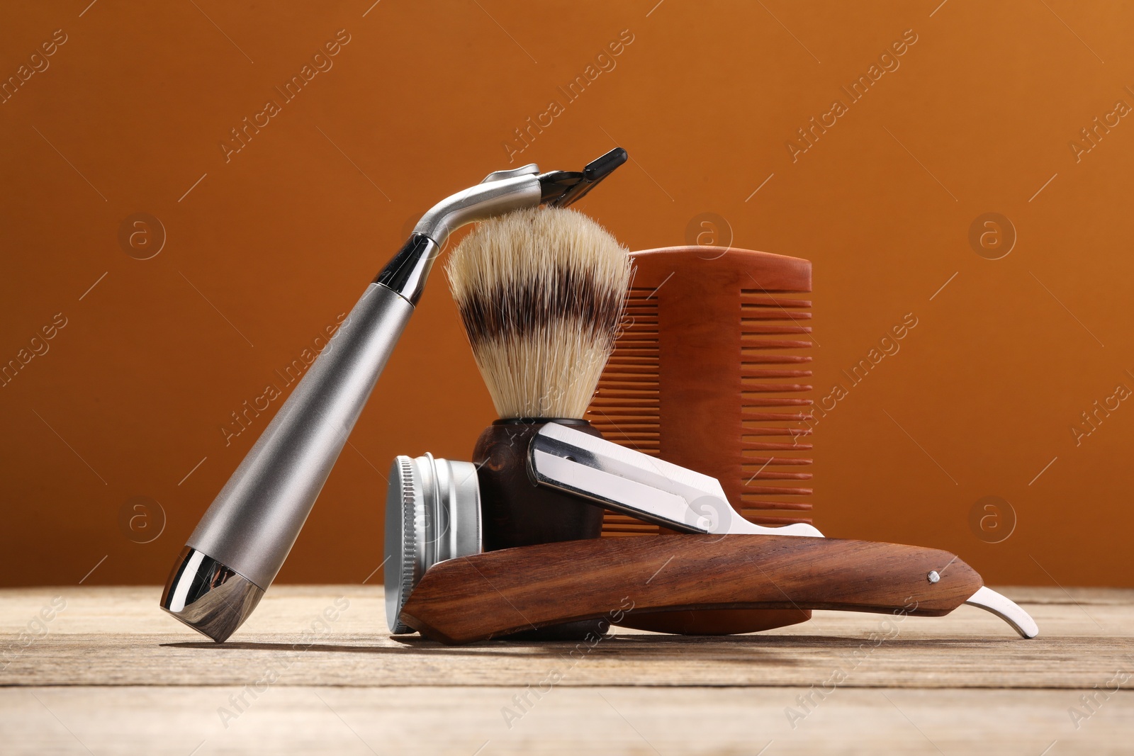 Photo of Moustache and beard styling tools on wooden table