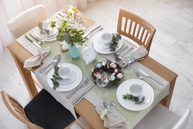 Beautiful Easter table setting with festive decor indoors, above view