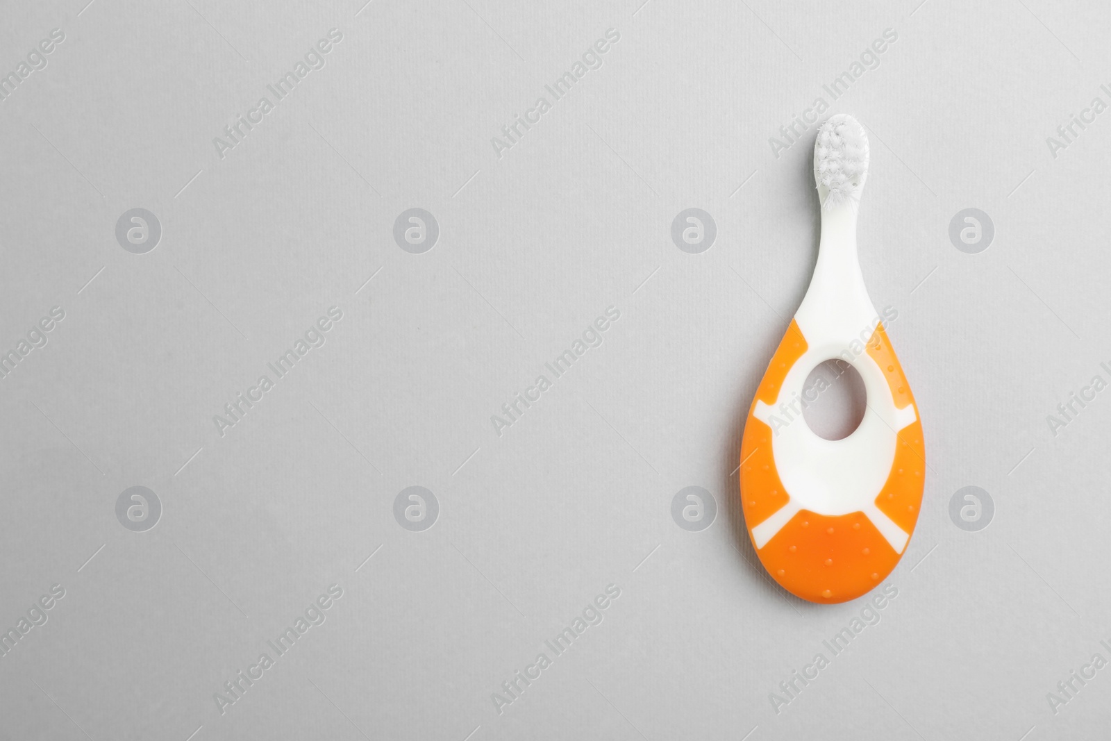 Photo of Manual toothbrush for child on gray background, top view with space for text