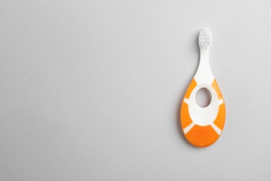 Manual toothbrush for child on gray background, top view with space for text