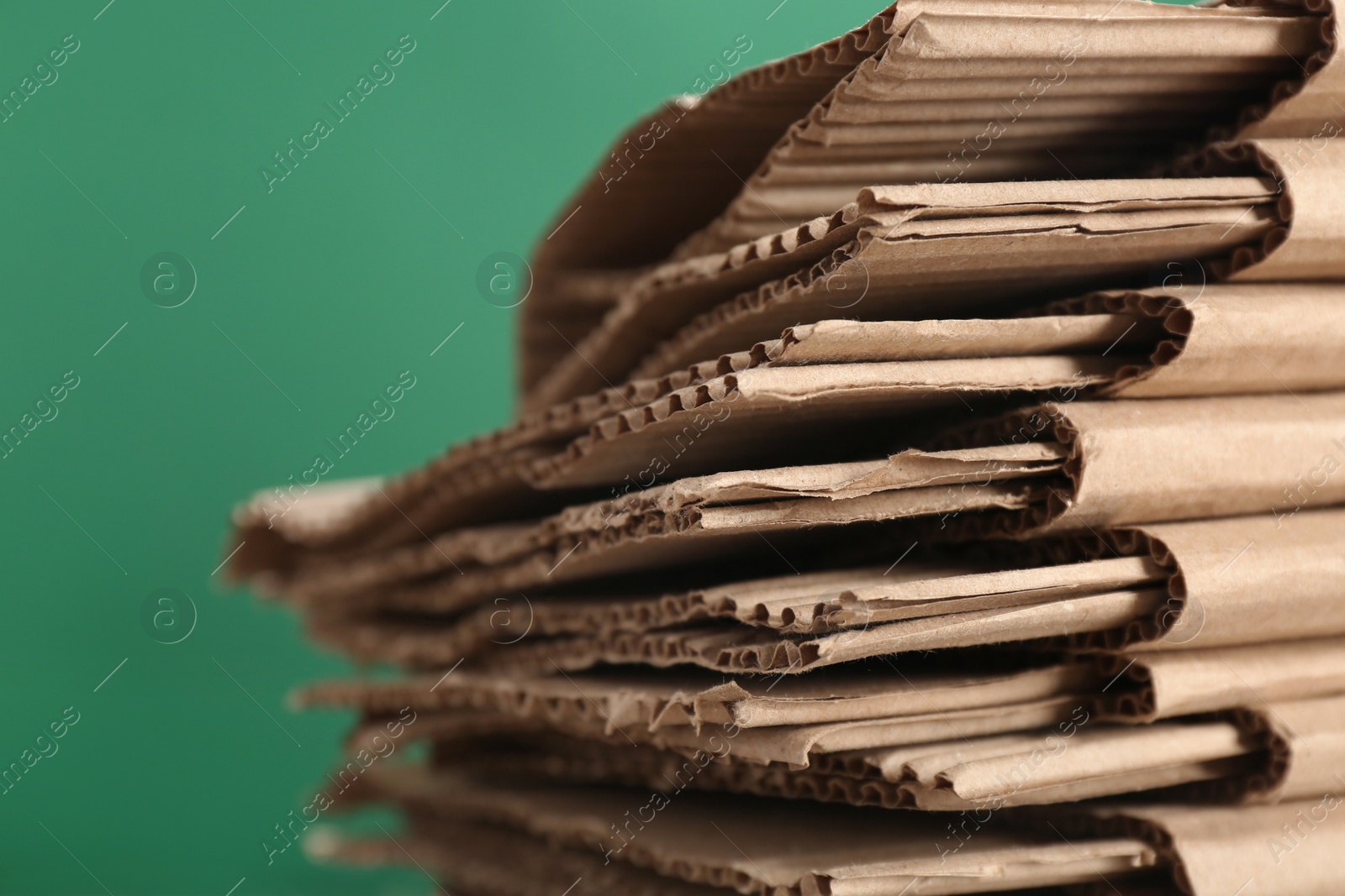 Photo of Cardboard pile on color background, space for text. Waste recycling concept