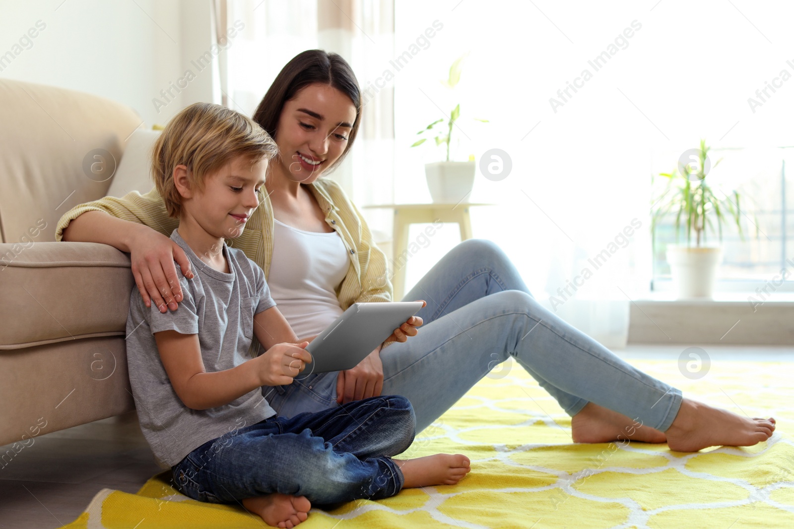 Photo of Mother and son reading E-book together at home