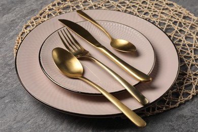 Stylish table setting with cutlery on grey surface, closeup