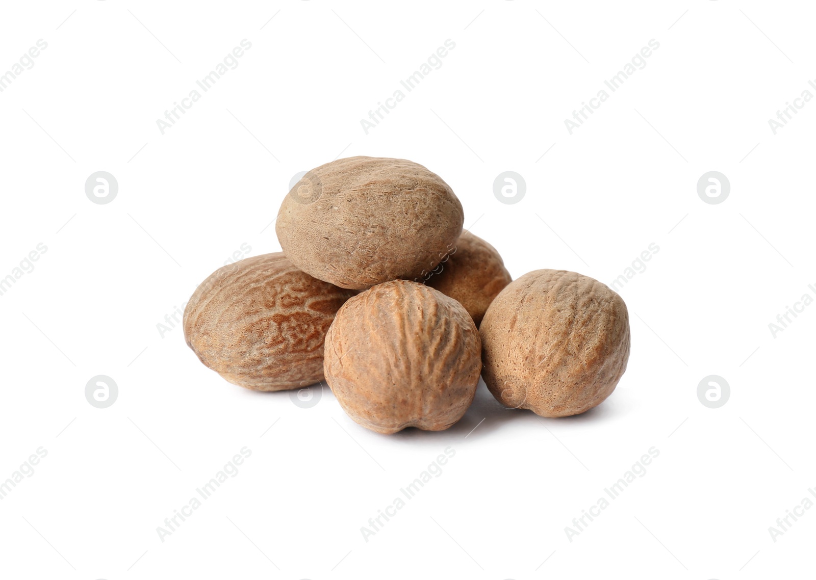 Photo of Heap of nutmeg seeds on white background