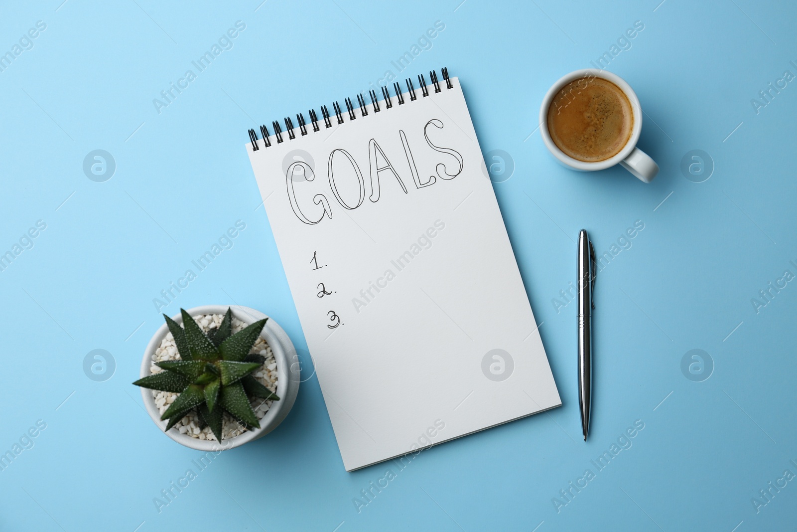 Photo of Planning concept. Empty list of goals in notebook, pen, coffee and houseplant on light blue background