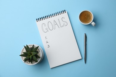 Photo of Planning concept. Empty list of goals in notebook, pen, coffee and houseplant on light blue background