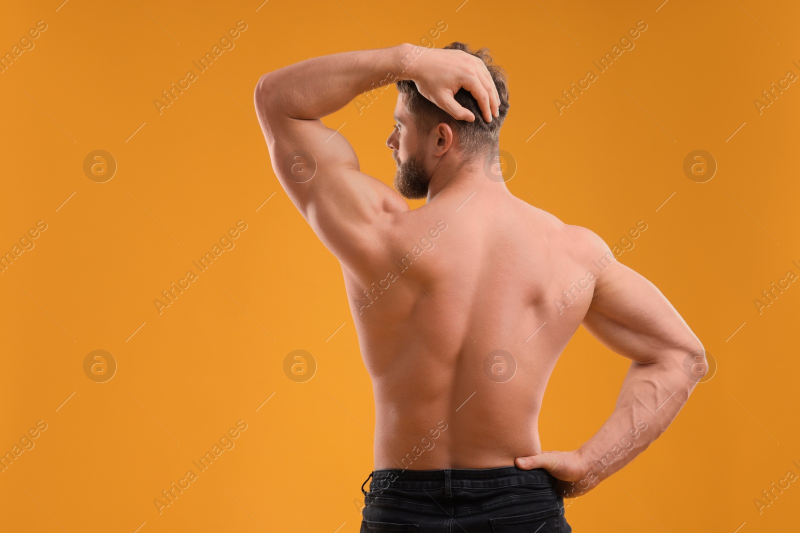 Photo of Muscular man on orange background, back view. Sexy body