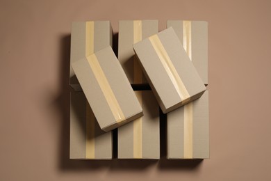 Many cardboard boxes on light brown background, flat lay