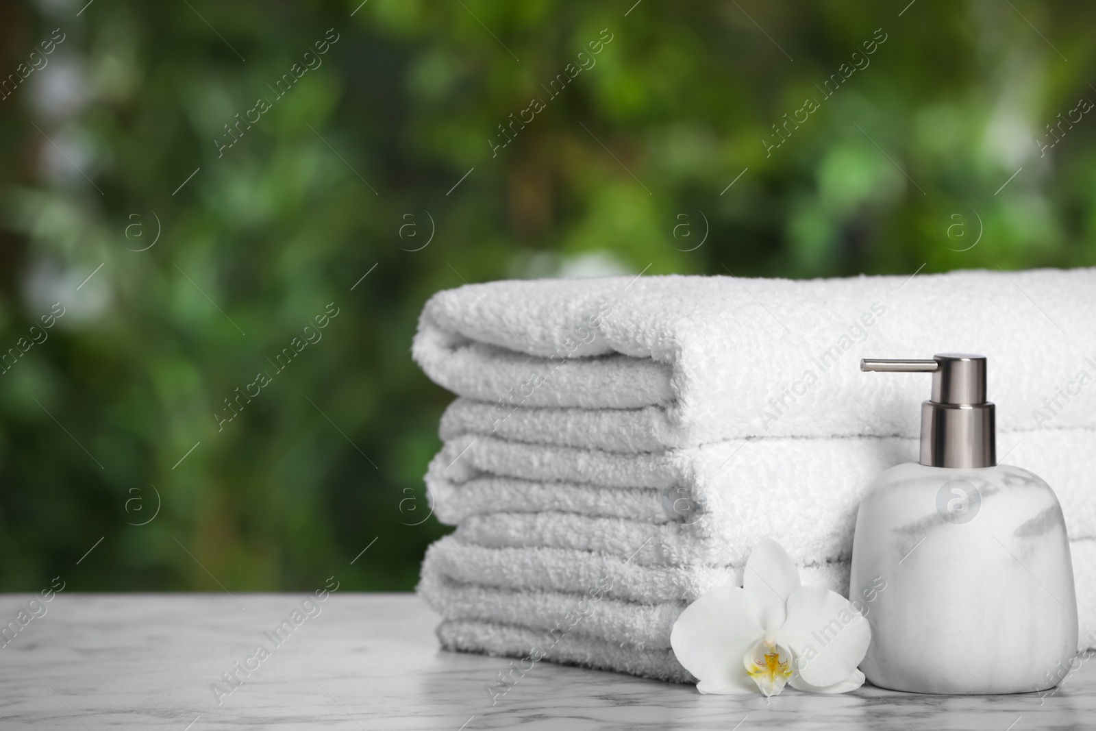 Photo of White soft towels on marble table outdoors, closeup. Space for text