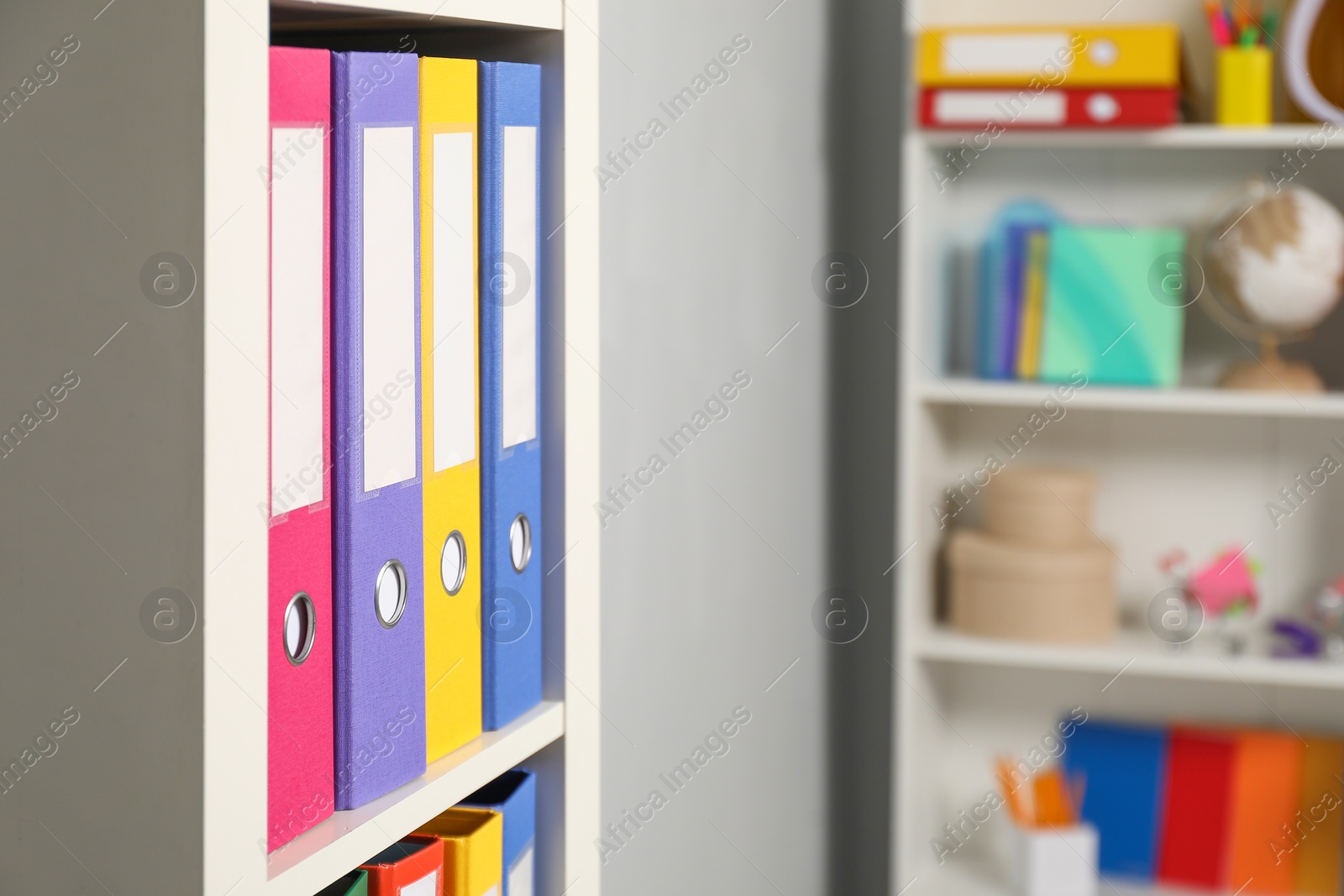 Photo of Colorful binder office folders on shelving unit indoors