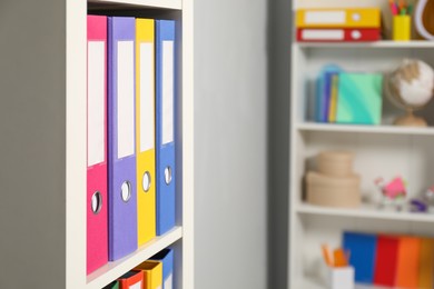 Colorful binder office folders on shelving unit indoors