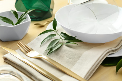 Photo of Elegant table setting with green leaves, closeup