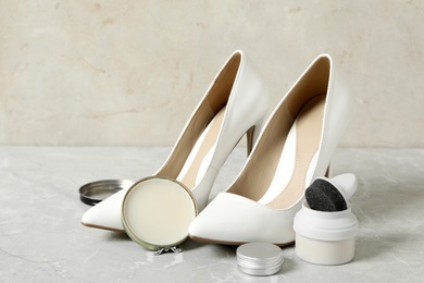 Photo of Composition with stylish footwear and shoe care accessories on light grey table