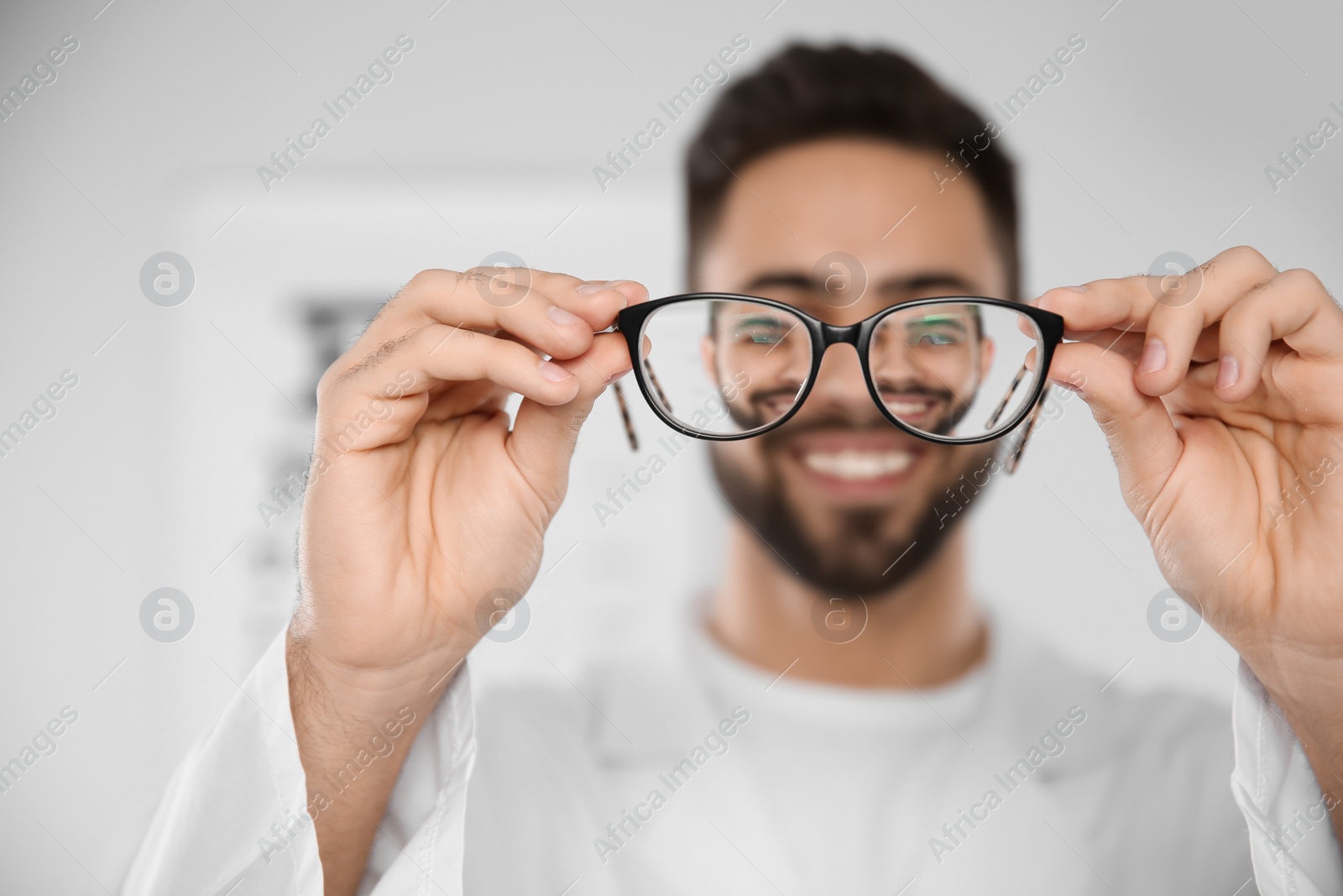 Photo of Male ophthalmologist with eyeglasses in clinic, closeup