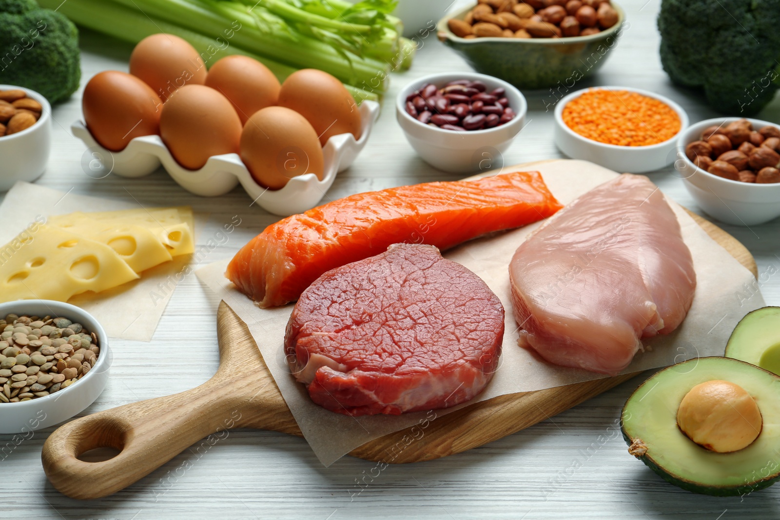 Photo of Fresh meat and other products on white wooden table. Sources of essential amino acids