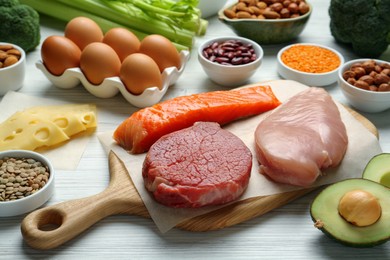 Photo of Fresh meat and other products on white wooden table. Sources of essential amino acids