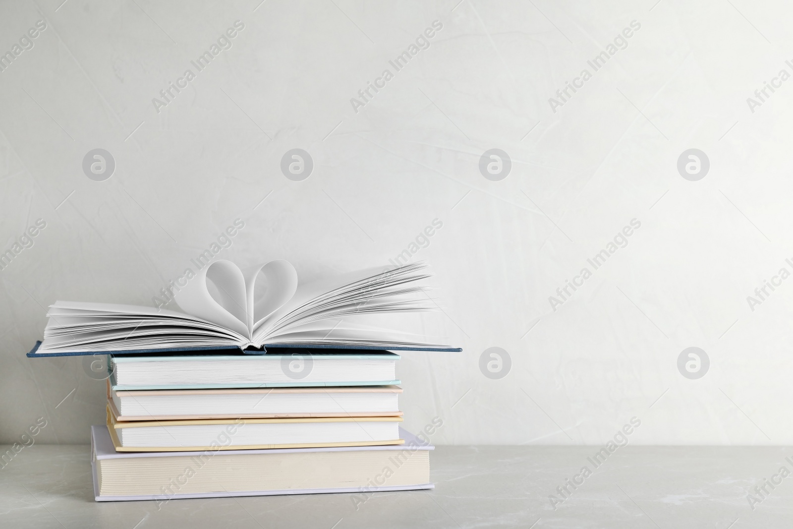 Photo of Stack of hardcover books on table against white background, space for text