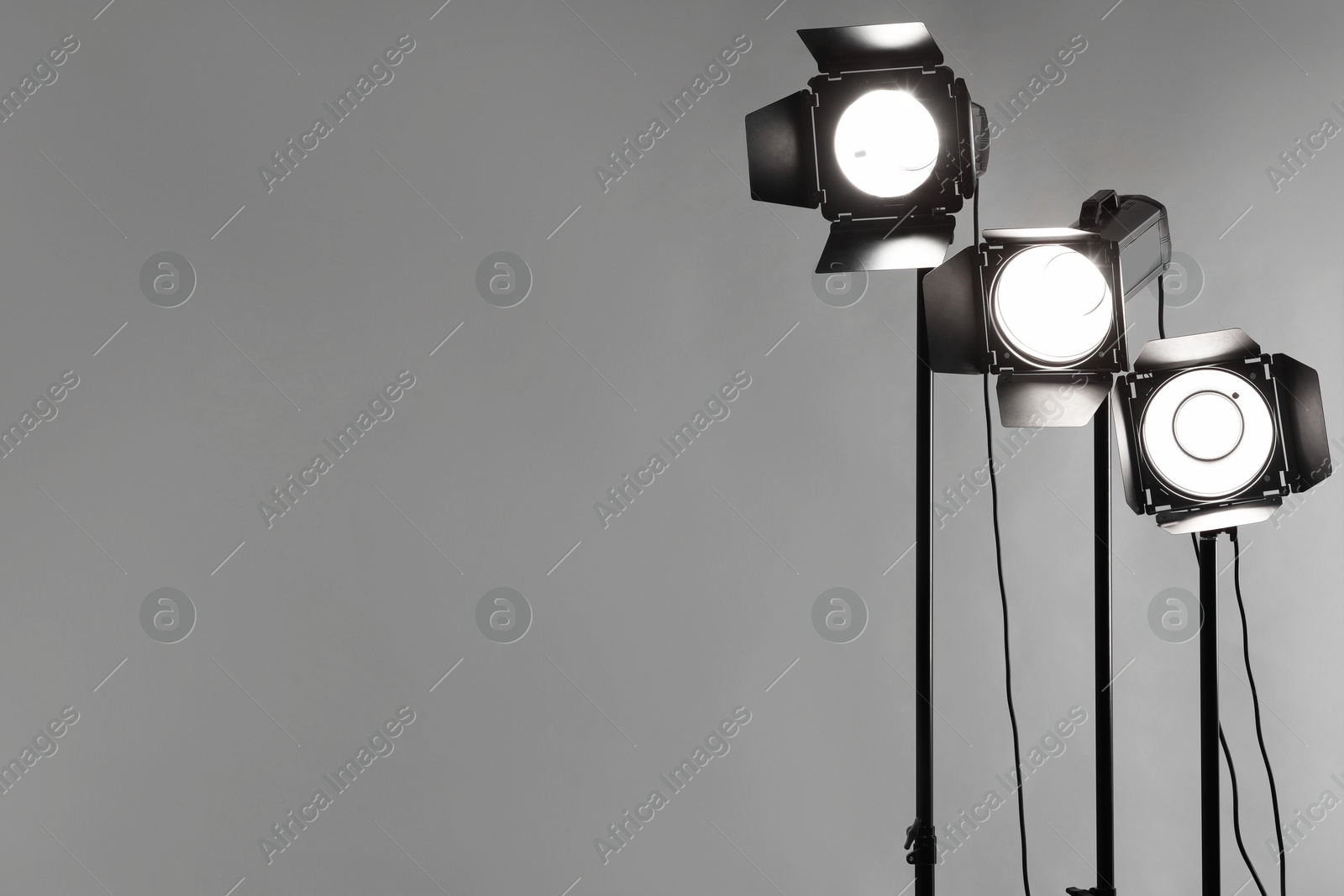 Photo of Grey photo background and professional lighting equipment in studio. Space for text