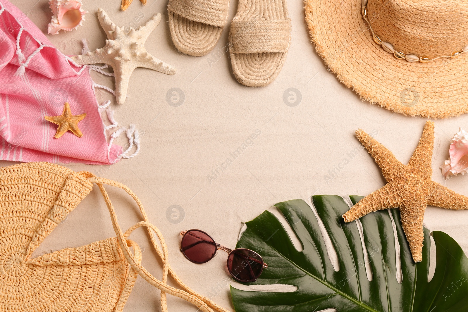 Photo of Frame of different beach accessories on sand, flat lay. Space for text