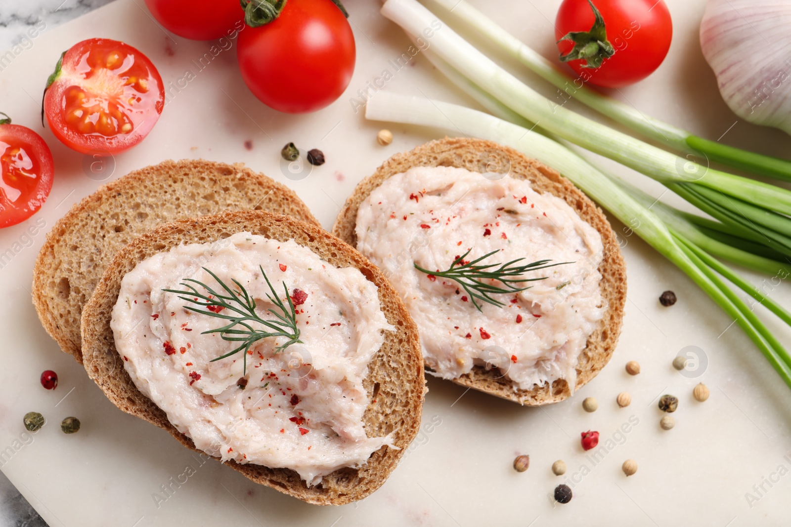 Photo of Sandwiches with delicious lard spread and vegetables on board, flat lay