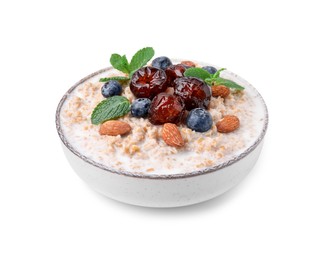 Tasty wheat porridge with milk, dates, blueberries and almonds in bowl isolated on white