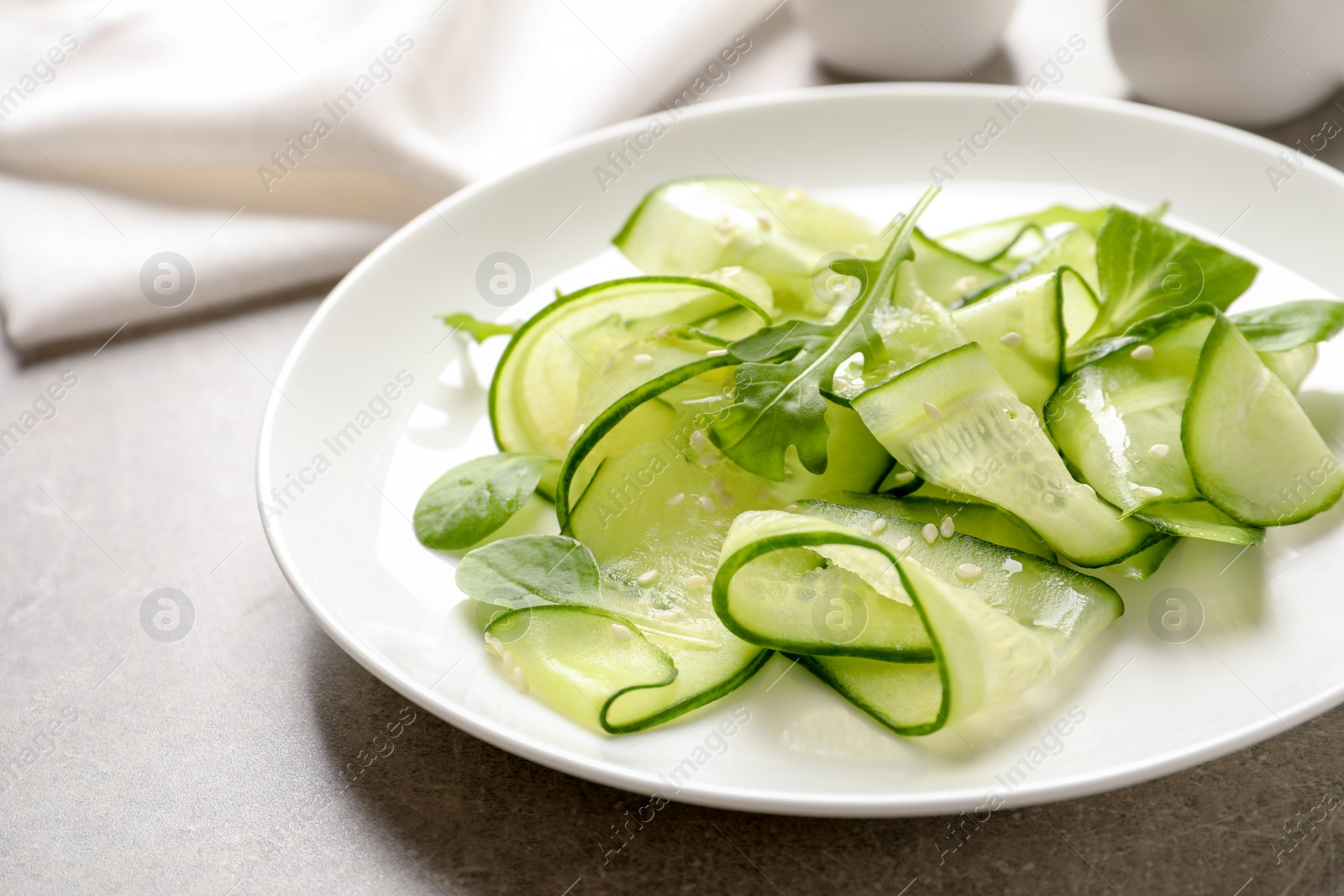 Photo of Plate with delicious cucumber salad on table, closeup