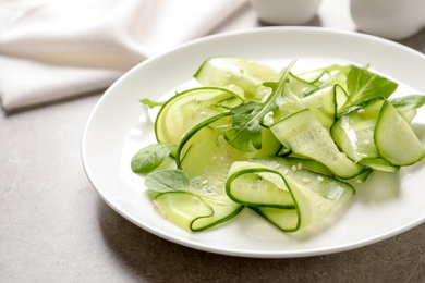 Photo of Plate with delicious cucumber salad on table, closeup