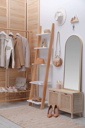 Photo of Modern hallway interior with stylish furniture and wooden hanger for keys on white wall