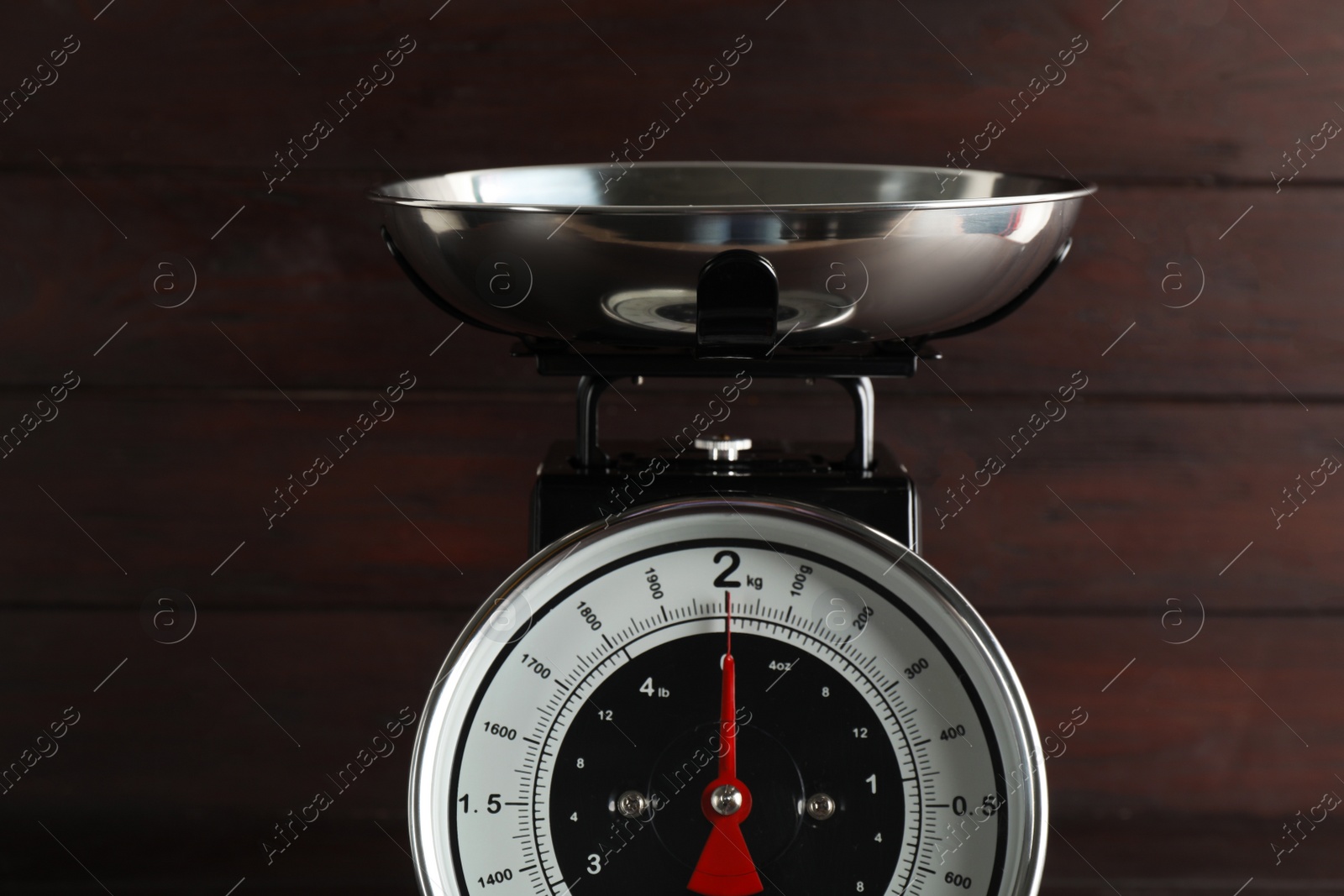 Photo of Retro mechanical kitchen scale on wooden background, closeup