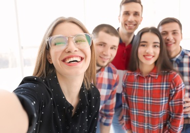 Photo of Happy friends taking selfie indoors