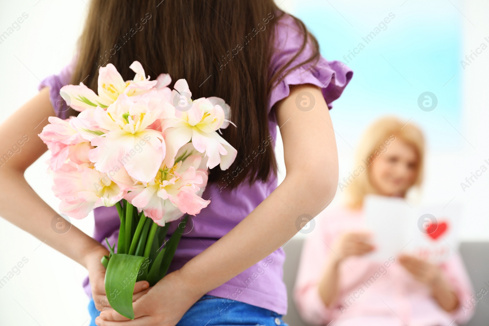 Photo of Little daughter congratulating her mature mom at home, closeup. Happy Mother's Day