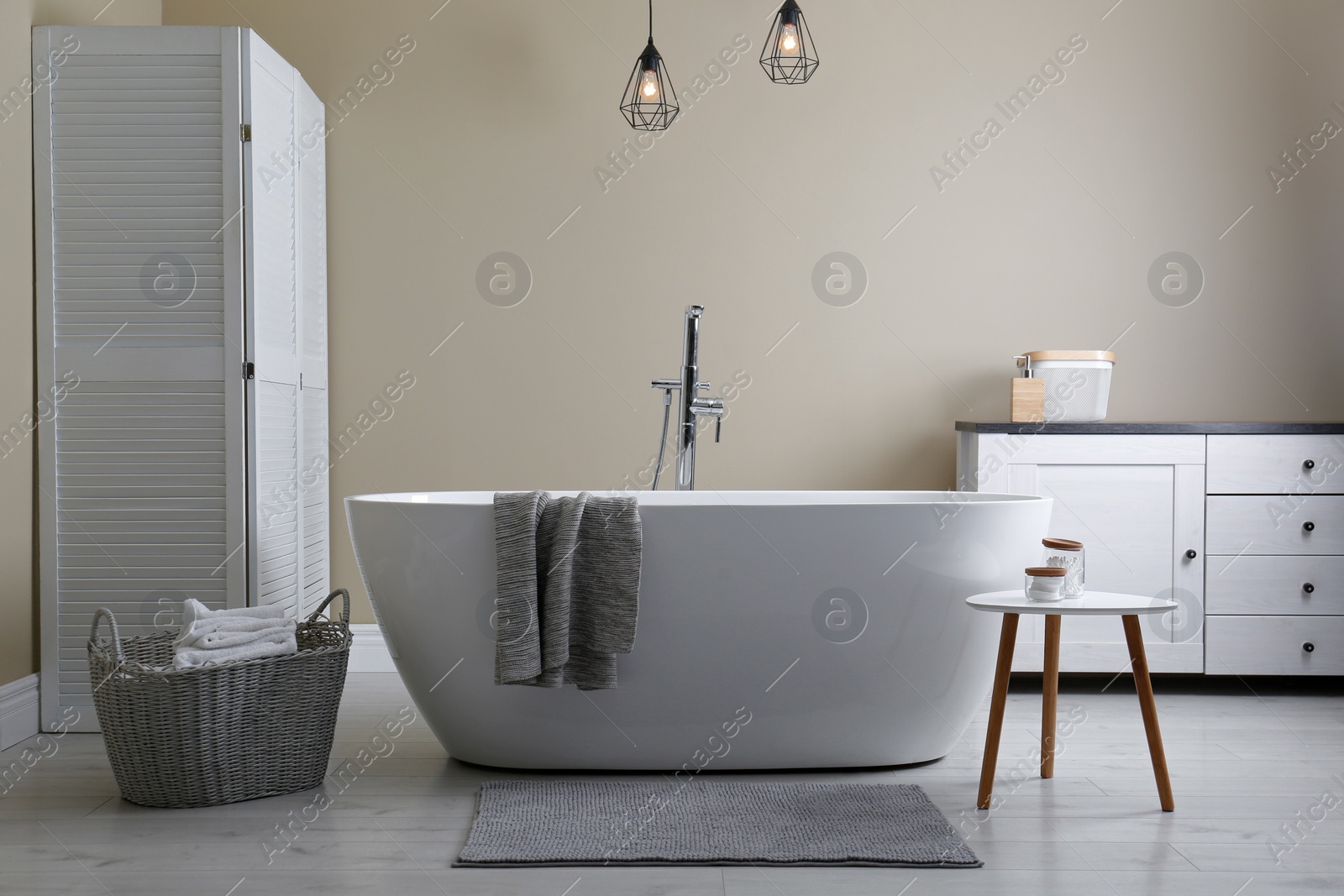 Photo of Soft grey mat on floor near tub in bathroom. Interior design