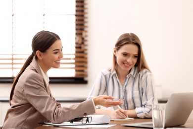 Female insurance agent consulting young woman in office